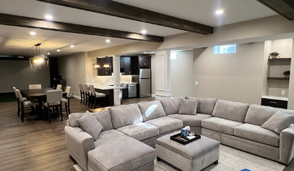 Modern basement living room with gray sectional and dining area