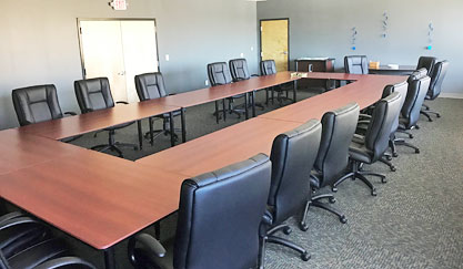 U-shaped conference table with black office chairs