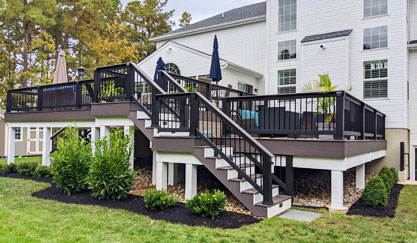 Black-railed elevated deck and stairs beside white house