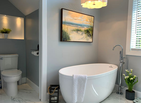 Modern bathroom with freestanding tub and toilet alcove