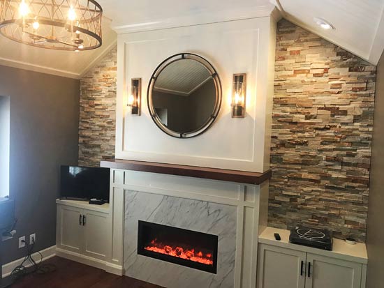 Modern fireplace with stone accent wall and round mirror